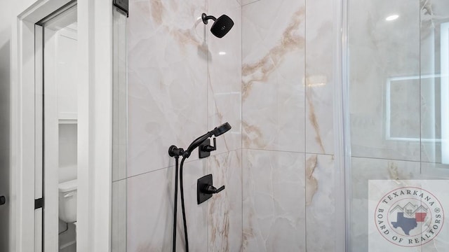 interior details featuring a shower stall and toilet