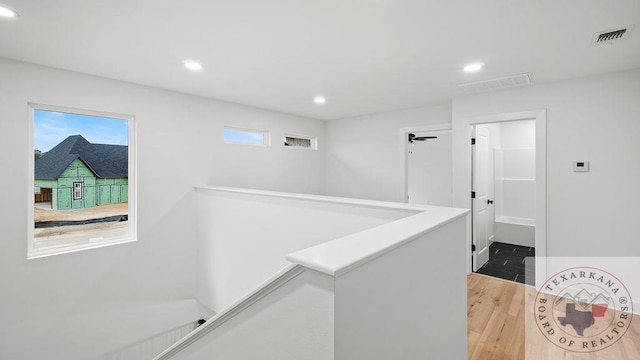 corridor featuring recessed lighting, visible vents, an upstairs landing, and wood finished floors