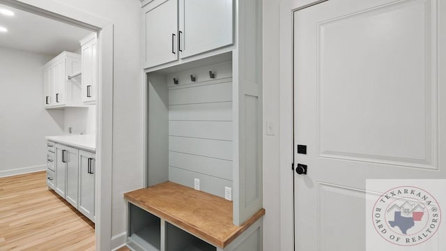 mudroom with light wood finished floors and baseboards