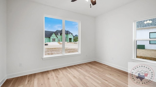 unfurnished room with wood finished floors, a ceiling fan, and baseboards