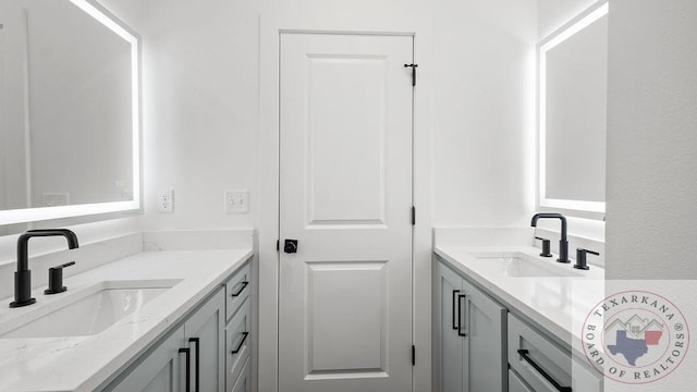 bathroom featuring two vanities and a sink