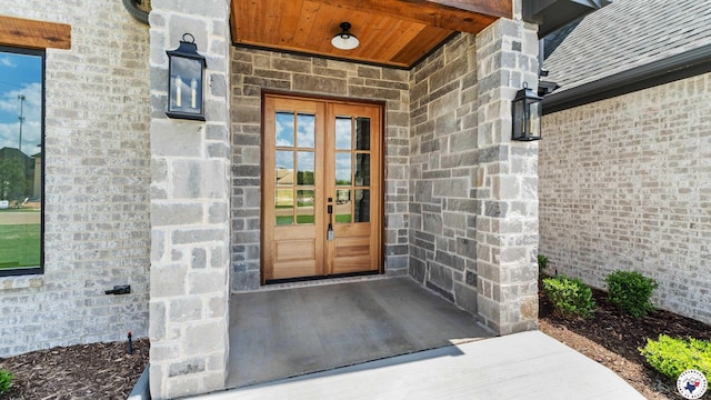 property entrance featuring french doors and stone siding