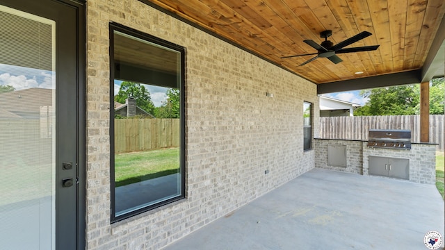 view of patio / terrace featuring exterior kitchen, a ceiling fan, area for grilling, and fence