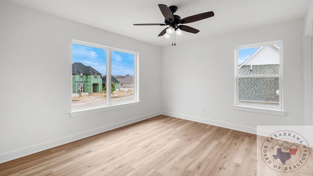 empty room with light wood-style floors, a healthy amount of sunlight, and baseboards