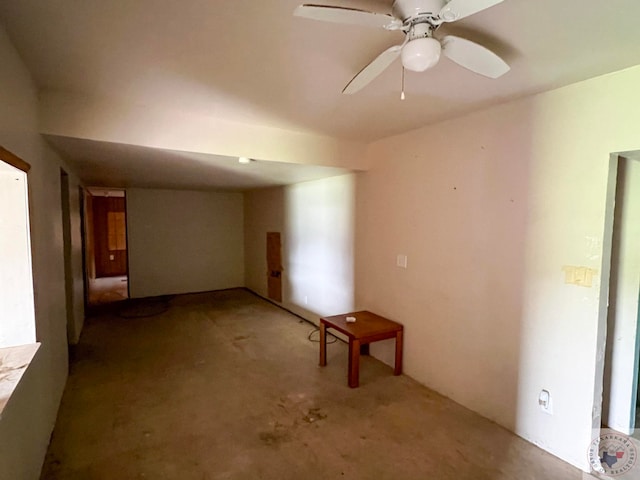 spare room with a ceiling fan and concrete floors