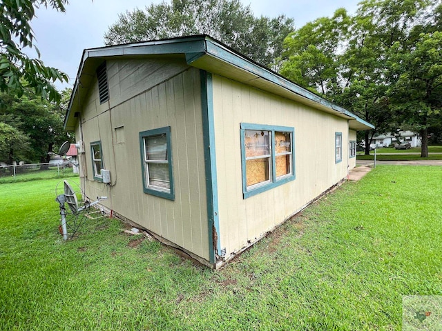 view of property exterior with fence and a yard