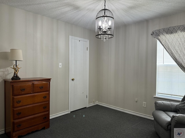 sitting room with dark carpet, a textured ceiling, and a notable chandelier