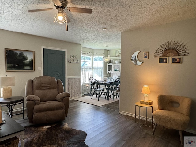 living room with ceiling fan, a textured ceiling, and dark hardwood / wood-style flooring