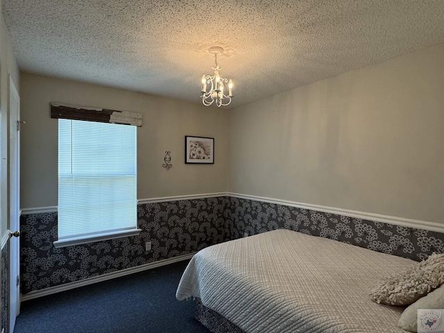 bedroom featuring a chandelier, carpet, and a textured ceiling