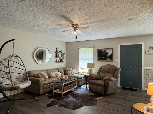 living room with ceiling fan, dark wood-type flooring, and a textured ceiling