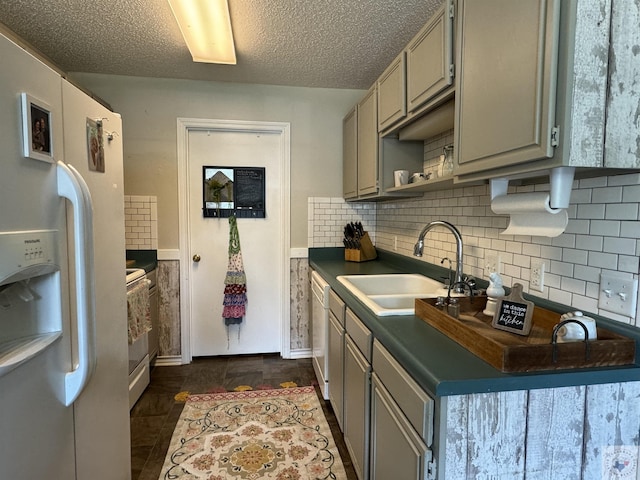 kitchen featuring sink, tasteful backsplash, gray cabinets, white appliances, and a textured ceiling