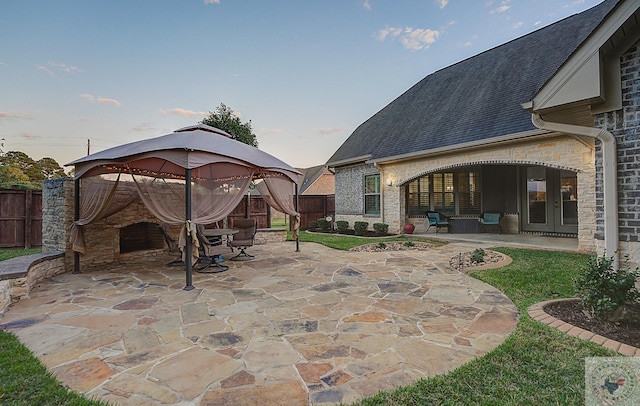 patio terrace at dusk featuring french doors and a gazebo