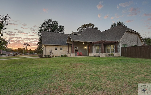 view of front of home with a pergola and a lawn