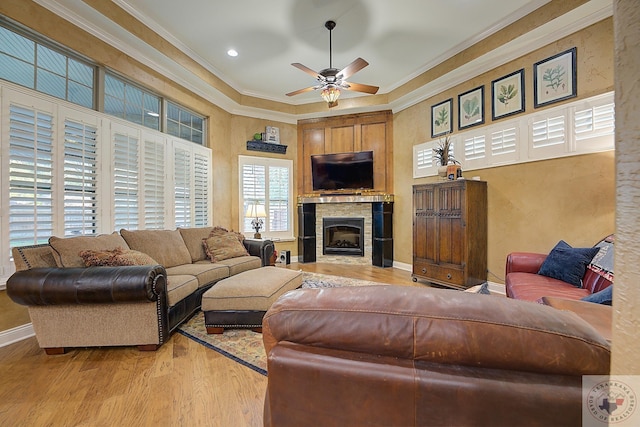 living room featuring light hardwood / wood-style floors, ornamental molding, and ceiling fan