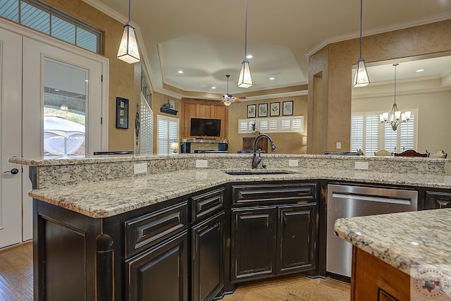 kitchen featuring light stone counters, sink, hanging light fixtures, and dishwasher