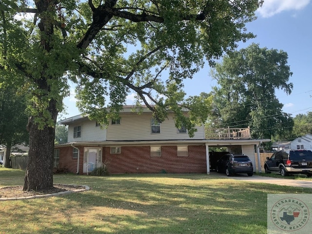 view of front of property featuring a front lawn, an attached carport, concrete driveway, and brick siding