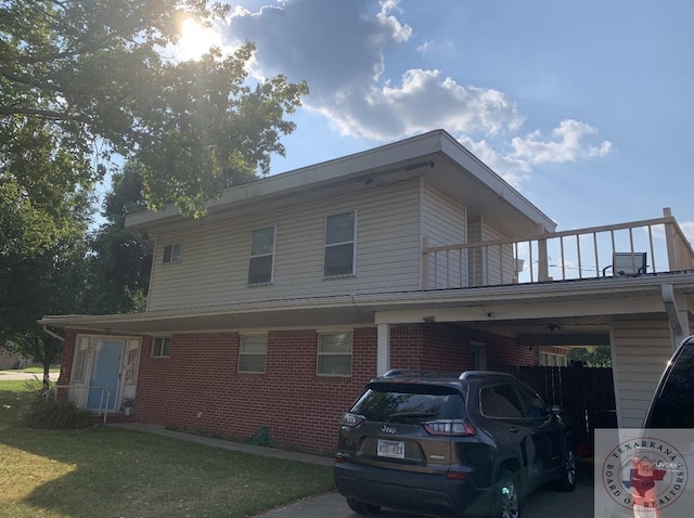 view of property exterior featuring a balcony, a carport, and brick siding