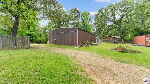 77 Big Rock Cir, Texarkana, AR 71854 - view of yard featuring an outbuilding, a detached garage, driveway, an outdoor structure, and view of scattered trees