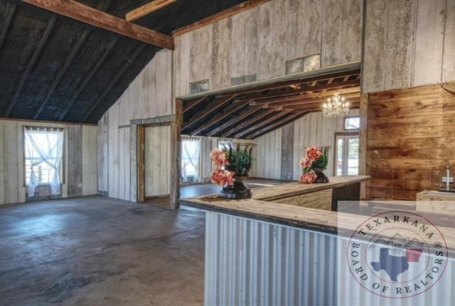 kitchen with a notable chandelier, vaulted ceiling, and concrete flooring