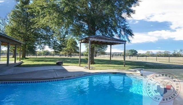 view of pool with a yard