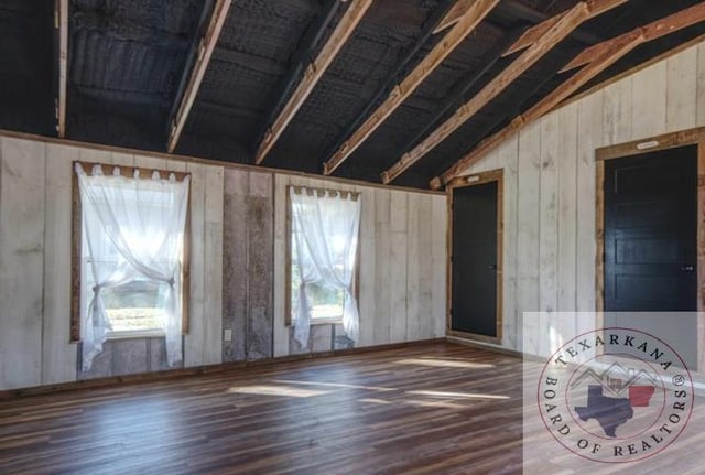 interior space featuring dark wood-type flooring and vaulted ceiling