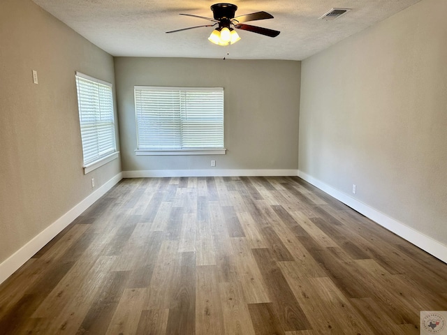 empty room featuring hardwood / wood-style floors, a textured ceiling, and ceiling fan