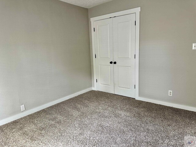 unfurnished bedroom with a closet and carpet