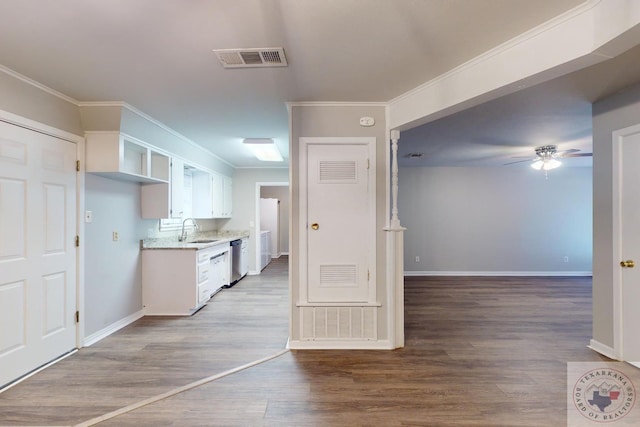 kitchen featuring stainless steel dishwasher, sink, white cabinets, and light wood-type flooring