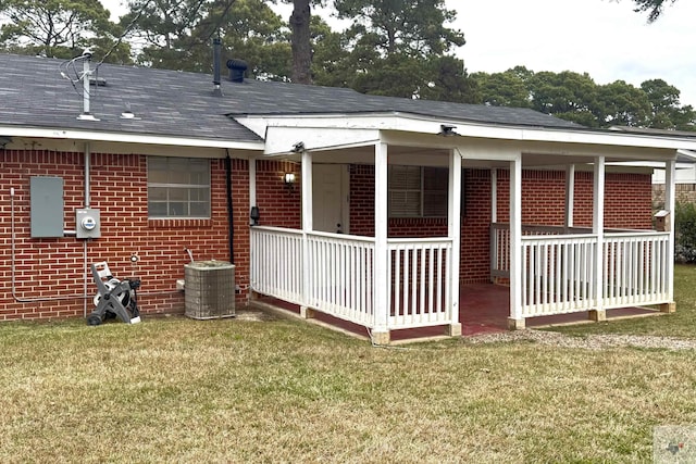 rear view of property featuring a porch, central AC, and a yard