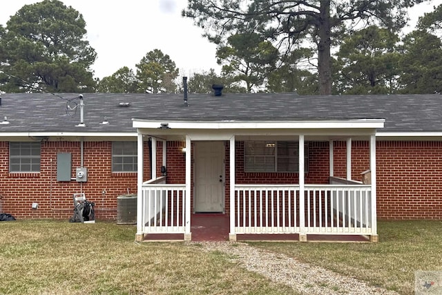 back of house with central AC unit and a lawn