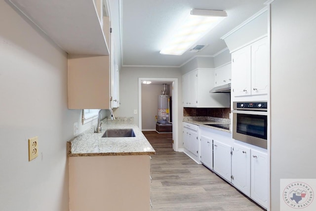 kitchen featuring white cabinets, water heater, sink, stainless steel oven, and crown molding