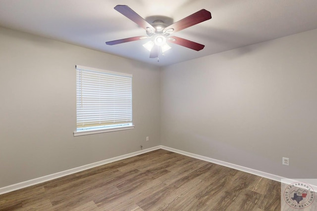 spare room featuring dark wood-type flooring and ceiling fan