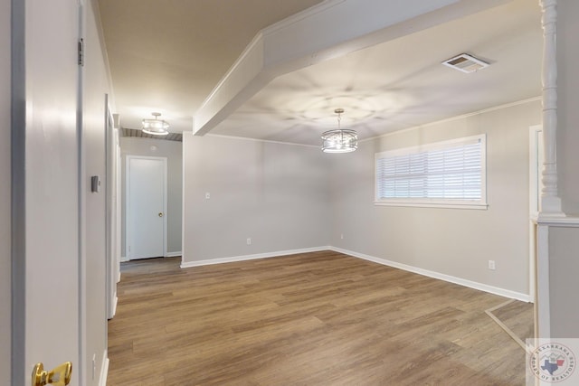 empty room with hardwood / wood-style flooring and crown molding