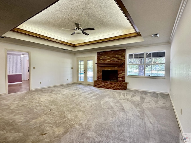 unfurnished living room featuring light colored carpet, crown molding, and a tray ceiling