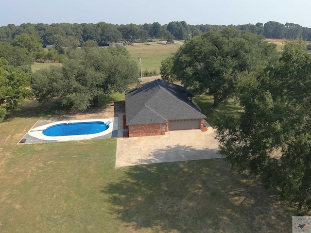 view of pool with a lawn and a rural view