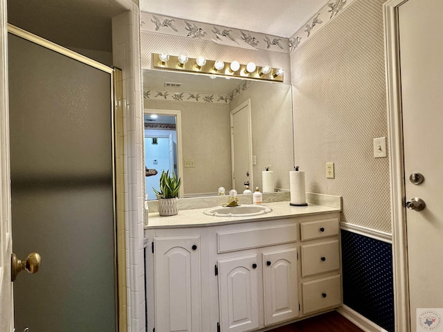 bathroom featuring walk in shower and vanity