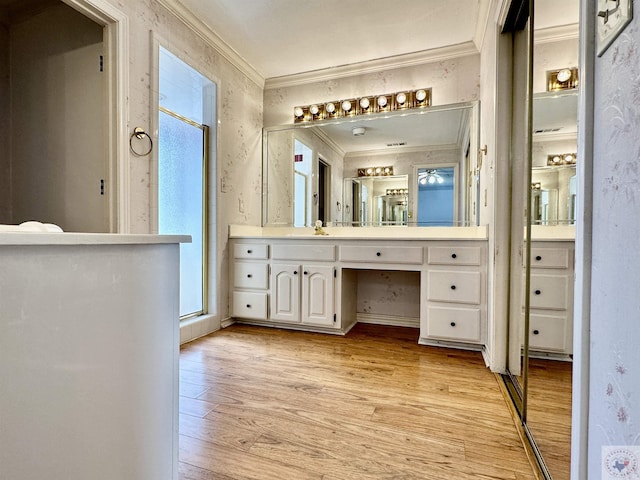 bathroom featuring ornamental molding, hardwood / wood-style floors, a shower with shower door, and vanity