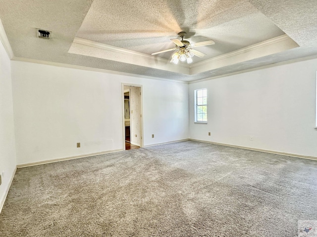 unfurnished room with carpet floors, a tray ceiling, and ornamental molding