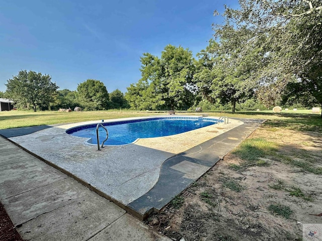 view of swimming pool featuring a yard