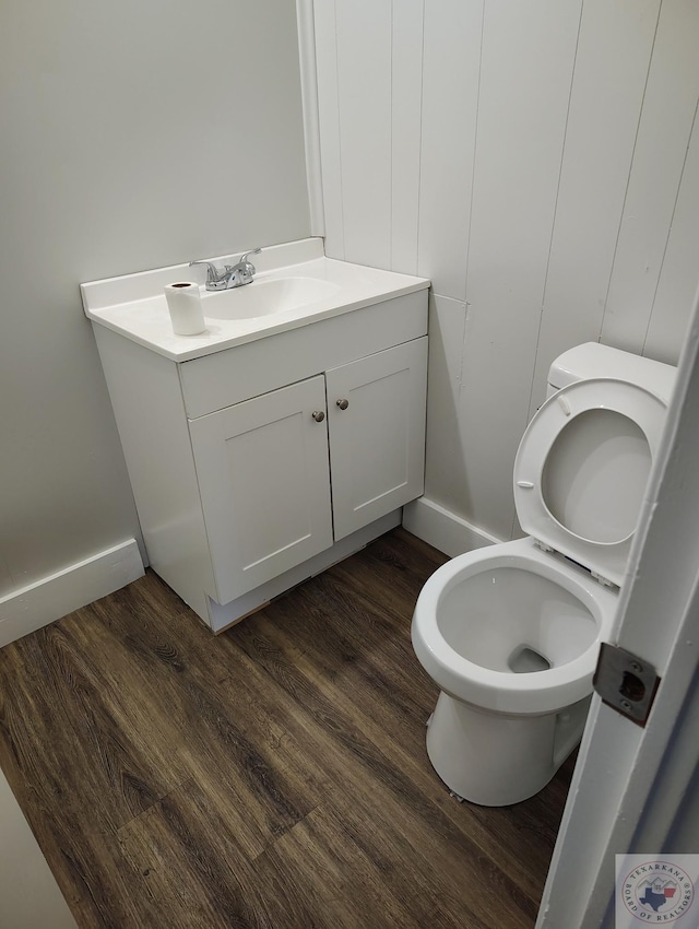 bathroom with hardwood / wood-style floors, toilet, and vanity