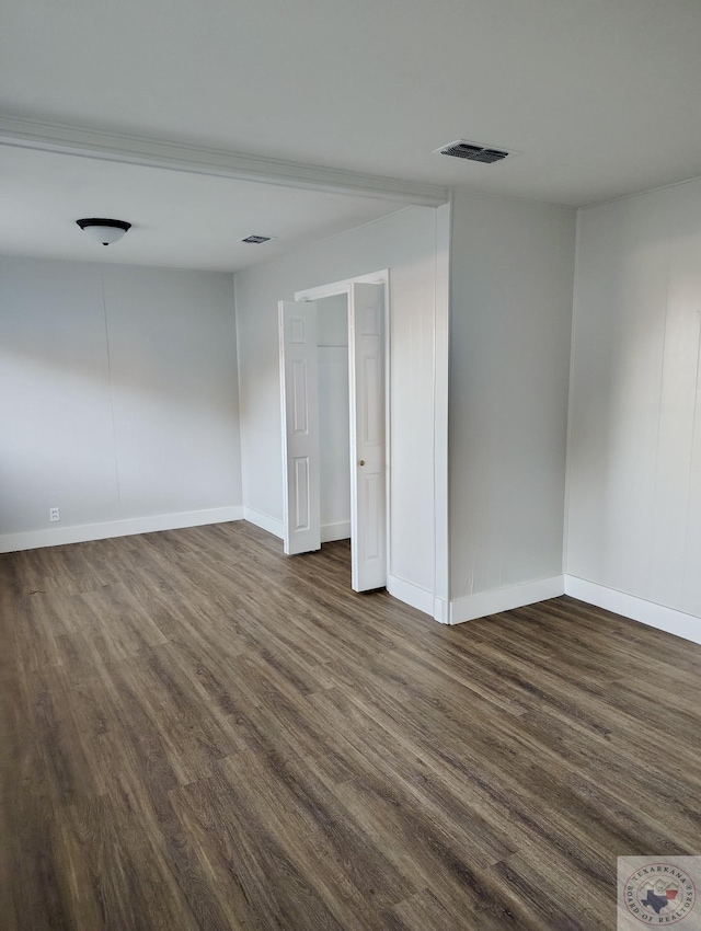 unfurnished bedroom with dark hardwood / wood-style flooring