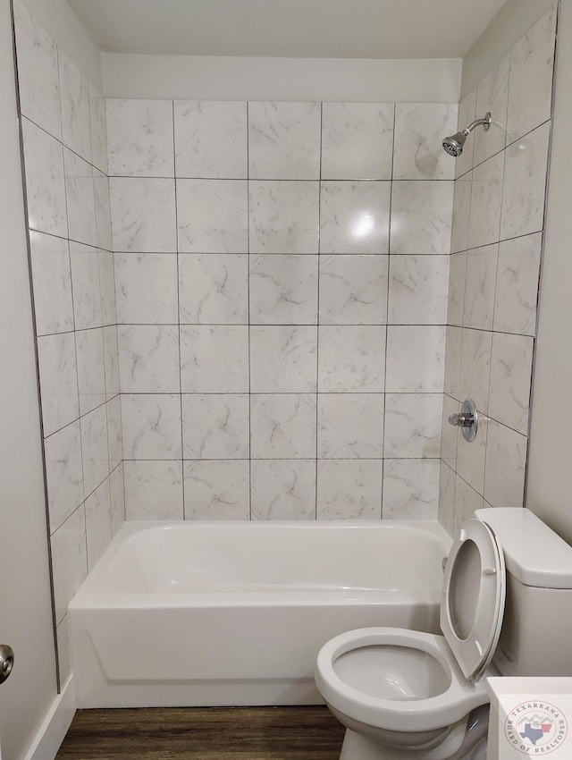 bathroom featuring toilet, tiled shower / bath combo, and hardwood / wood-style flooring