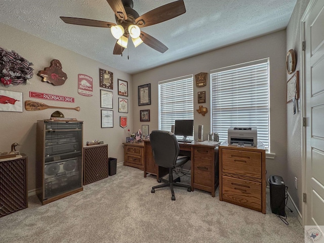 office area featuring light carpet, ceiling fan, and a textured ceiling