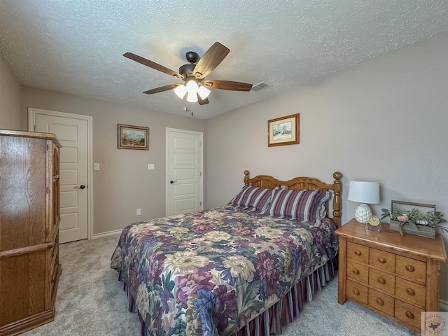 carpeted bedroom with ceiling fan and a textured ceiling