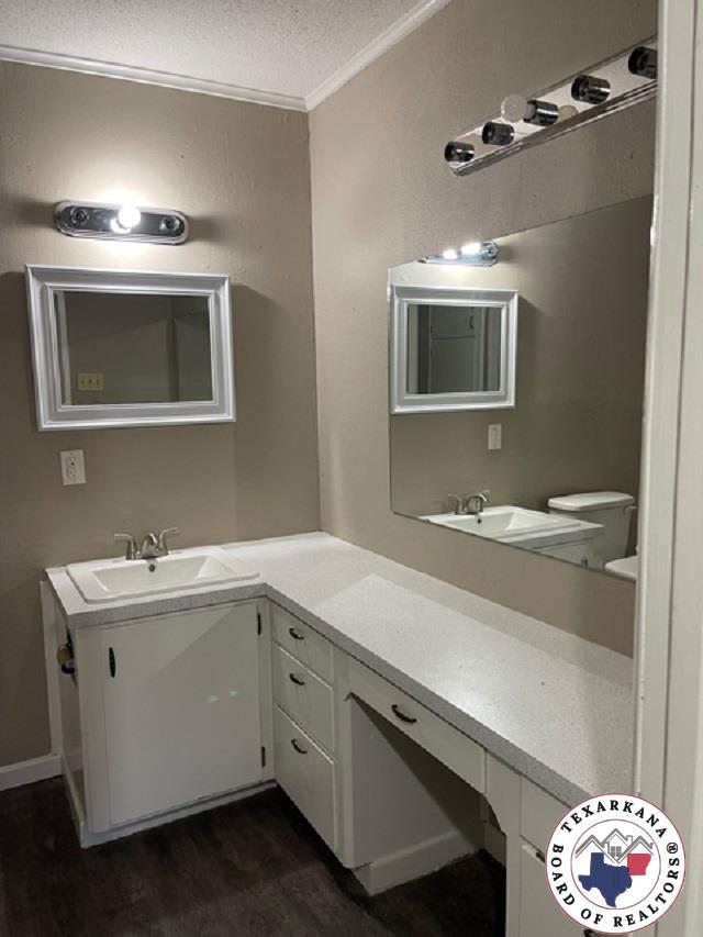 500 Wade Ln, Texarkana, TX 75501 - bathroom featuring ornamental molding, wood finished floors, vanity, and a textured ceiling