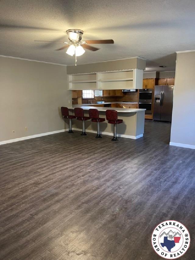 500 Wade Ln, Texarkana, TX 75501 - kitchen featuring stainless steel appliances, a ceiling fan, open floor plan, baseboards, and a peninsula