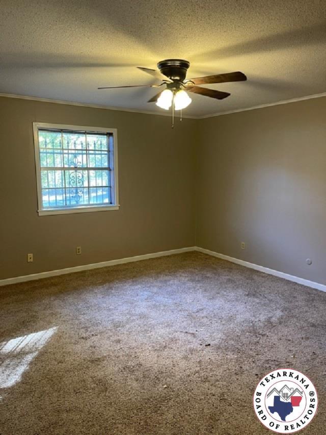 500 Wade Ln, Texarkana, TX 75501 - carpeted spare room with a textured ceiling, ornamental molding, ceiling fan, and baseboards