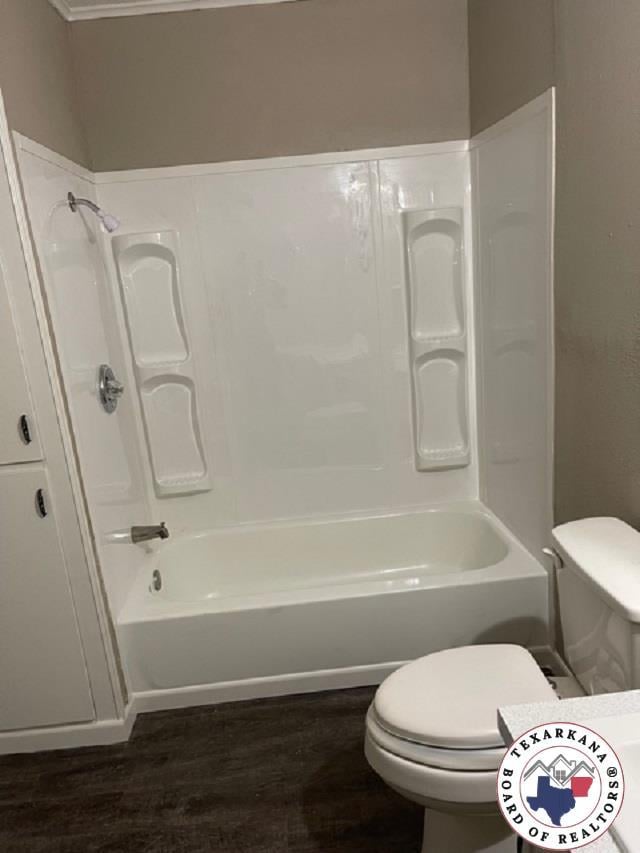 500 Wade Ln, Texarkana, TX 75501 - full bathroom with wood finished floors, toilet, and  shower combination