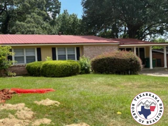 2311 Shady Ln, Texarkana, TX 75503 - ranch-style house with a front yard and a carport