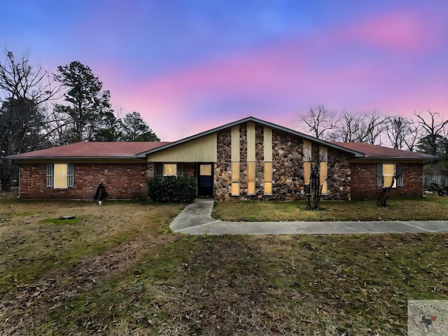 single story home with a lawn